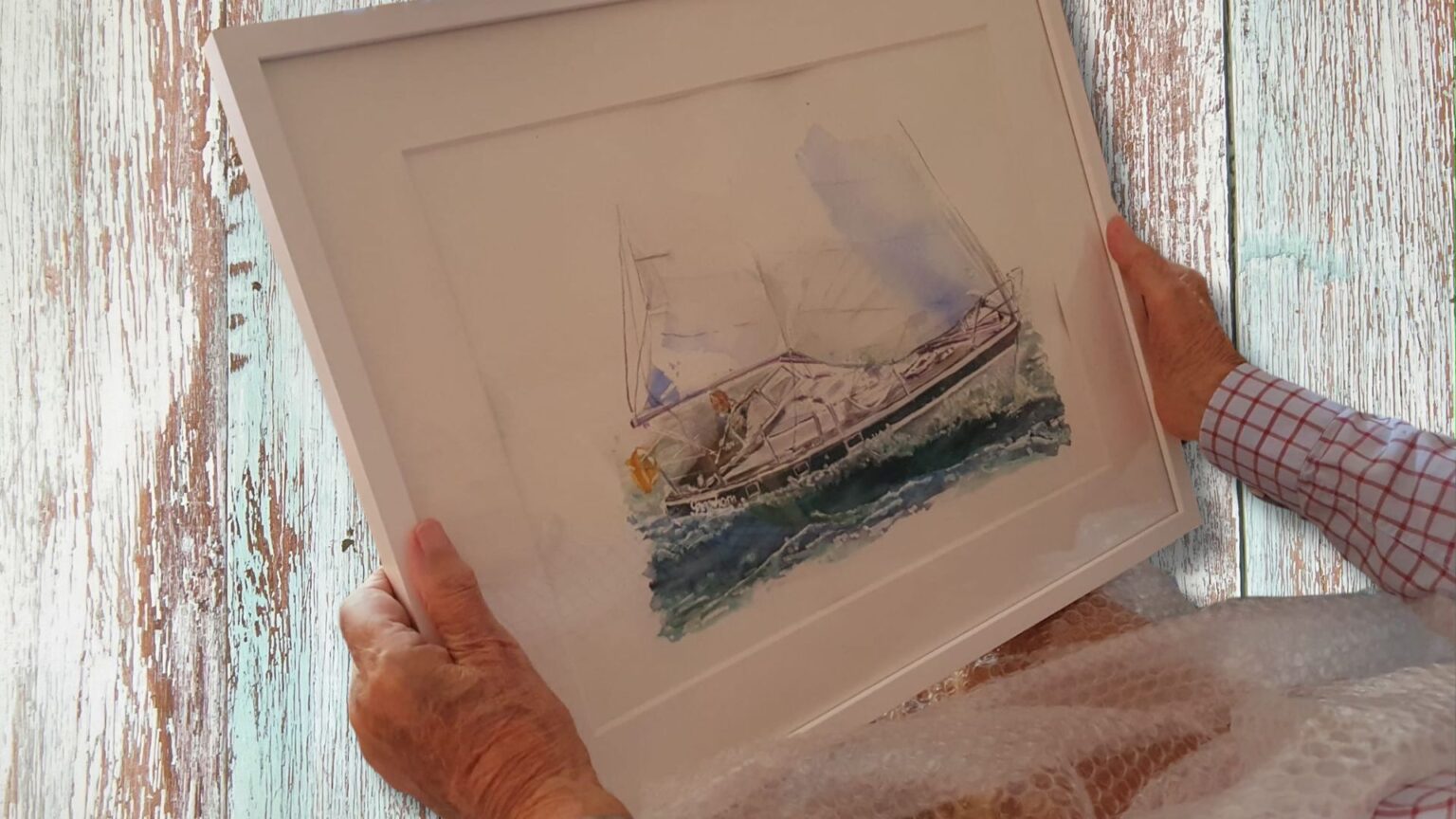 Gerahmtes Aquarellbild eines Segelbootes wird ausgepackt